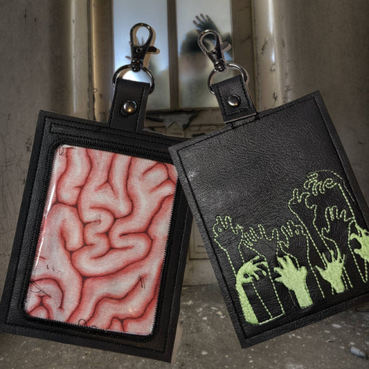 Braaiins glow in the dark vaccination card protector. Space for valuebles. Attach to purse, bag, backback or beltloops Vinyl, cork, leather.