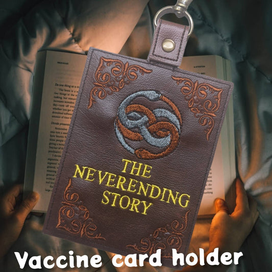 Neverending story vaccine card protector. Attach to purse, bag, backpack or beltloops Vinyl, vegan leather.